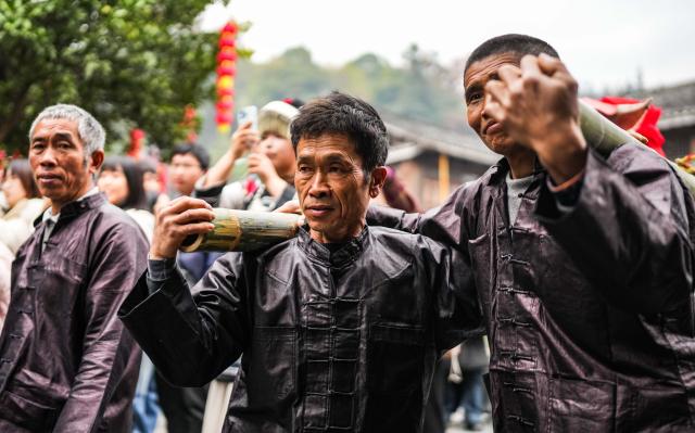 (251220) -- LIPING, Dec. 20, 2025 (Xinhua) -- A performance team parades during an event in celebration of Dong New Year at Zhaoxing Dong village of Liping County, Qiandongnan Miao and Dong Autonomous Prefecture, southwest China's Guizhou Province, Dec. 20, 2025. Dong New Year, a traditional festival for harvest and gathering, was enlisted as one of China's national intangible cultural heritages in 2011. Various activities were held in Liping County over the weekend. (Xinhua/Tao Liang)