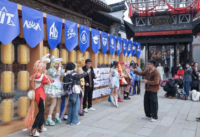 (251220) -- TONGXIANG, Dec. 20, 2025 (Xinhua) -- Tourists pose for photos with cosplayers in Tongxiang, east China's Zhejiang Province, Dec. 20, 2025. The festival kicked off here on Saturday and will last until Dec. 28. (Xinhua/Xu Yu)
