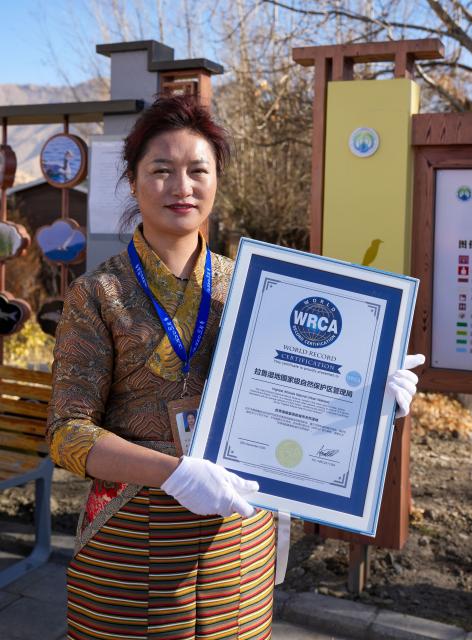 (251220) -- LHASA, Dec. 20, 2025 (Xinhua) -- A staff member of the Lhalu Wetland National Nature Reserve displays a certificate issued by the World Record Certification Agency (WRCA), in Lhasa, southwest China's Xizang Autonomous Region, Dec. 20, 2025. Verified by the World Record Certification Agency (WRCA), the Lhalu Wetland National Nature Reserve has been confirmed as the "highest altitude natural urban wetland." The certification ceremony was held at the wetland on Saturday.
   Located in the urban area of Lhasa, the wetland covers an area of 12.2 square kilometers at an average altitude of 3,649 meters. (Xinhua/Jigme Dorje)