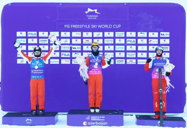(251221) -- ZHANGJIAKOU, Dec. 21, 2025 (Xinhua) -- Gold medalist Li Tianma (C) of China, silver medalist Qi Guangpu (L) of China and bronze medalist Noe Roth of Switzerland pose during the awarding ceremony for the men's freeski aerials final of FIS Freeski World Cup 2025 in Zhangjiakou, north China's Hebei Province, Dec. 20, 2025. (Photo by Wu Diansen/Xinhua)
