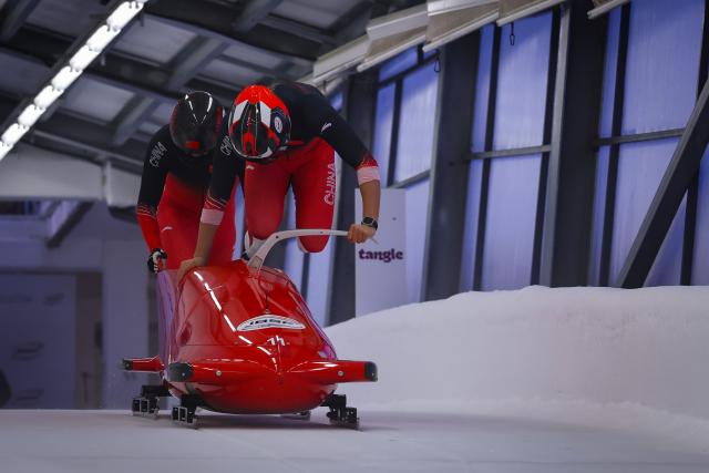 (251221) -- SIGULDA, Dec. 21, 2025 (Xinhua) -- Li Chunjian (front) and Ren Jianzhang of China compete during the 2-man bobsleigh heat at the IBSF Bobsleigh and Skeleton World Cup in Sigulda, Latvia, Dec. 20, 2025. (Photo by Edijs Palens/Xinhua)