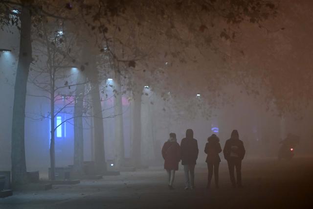 (251221) -- SKOPJE, Dec. 21, 2025 (Xinhua) -- People walk on a street as fog and pollution cover Skopje, North Macedonia, Dec. 20, 2025. Restrictive measures have been introduced in Strumica and Kicevo due to extremely high levels of air pollution. As of Dec. 19, they are also in effect in Skopje. (Photo by Tomislav Georgiev/Xinhua)