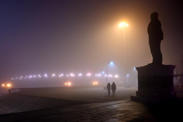 (251221) -- SKOPJE, Dec. 21, 2025 (Xinhua) -- People walk on a street as fog and pollution cover Skopje, North Macedonia, Dec. 20, 2025. Restrictive measures have been introduced in Strumica and Kicevo due to extremely high levels of air pollution. As of Dec. 19, they are also in effect in Skopje. (Photo by Tomislav Georgiev/Xinhua)