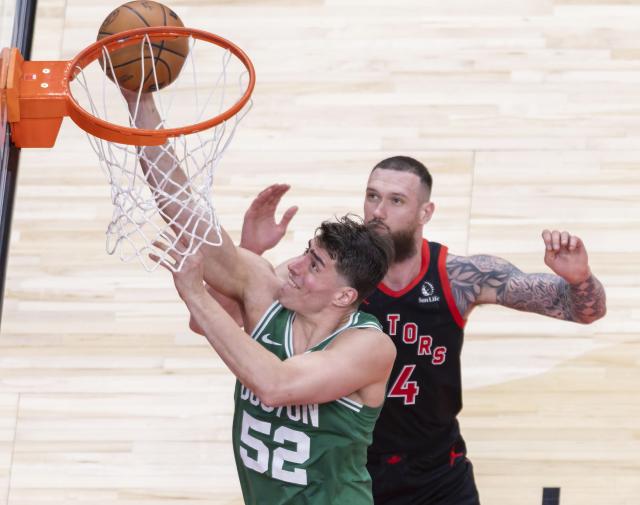 (251221) -- TORONTO, Dec. 21, 2025 (Xinhua) -- Luka Garza (front) of Boston Celtics goes for a layup during the 2025-2026 NBA regular season game between Toronto Raptors and Boston Celtics in Toronto, Canada, on Dec. 20, 2025. (Xinhua/Zou Zheng)