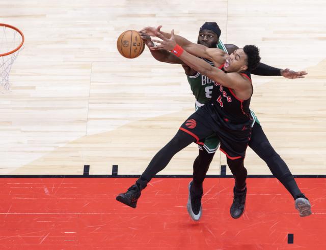 (251221) -- TORONTO, Dec. 21, 2025 (Xinhua) -- Scottie Barnes (front) of Toronto Raptors fights for a rebound with Neemias Queta of Boston Celtics during the 2025-2026 NBA regular season game between Toronto Raptors and Boston Celtics in Toronto, Canada, on Dec. 20, 2025. (Xinhua/Zou Zheng)