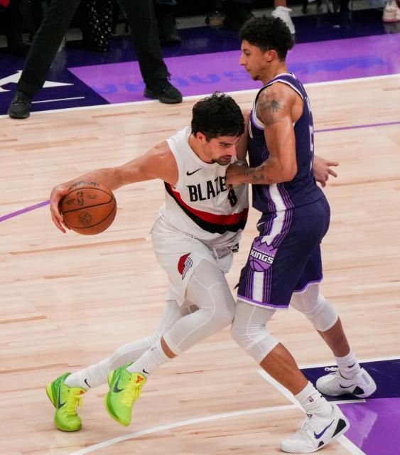 (251221) -- SACRAMENTO, Dec. 21, 2025 (Xinhua) -- Portland Trail Blazers' Deni Avdija (L) breaks through during the 2025-2026 NBA regular season match between Portland Trail Blazers and Sacramento Kings in Sacramento, the United States, on Dec. 20, 2025. (Photo by Sun Yuxuan/Xinhua)
