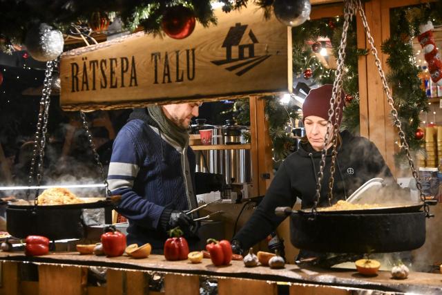 (251221) -- TALLINN, Dec. 21, 2025 (Xinhua) -- Estonian farmers prepare traditional Christmas dishes for visitors at a Christmas market on Town Hall Square in Tallinn, Estonia, Dec. 20, 2025. (Photo by Sergei Stepanov/Xinhua)