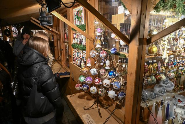 (251221) -- TALLINN, Dec. 21, 2025 (Xinhua) -- People choose handmade Christmas ornaments at a Christmas market on Town Hall Square in Tallinn, Estonia, Dec. 20, 2025. (Photo by Sergei Stepanov/Xinhua)