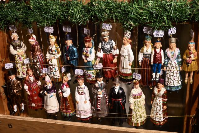 (251221) -- TALLINN, Dec. 21, 2025 (Xinhua) -- This photo taken on Dec. 20, 2025 shows handmade Christmas ornaments shaped like figures in traditional folk costumes from various regions of Estonia at a Christmas market on Town Hall Square in Tallinn, Estonia. (Photo by Sergei Stepanov/Xinhua)