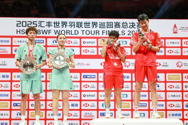 (251221) -- HANGZHOU, Dec. 21, 2025 (Xinhua) -- Gold medalists Feng Yanzhe (1st R)/Huang Dongping (2nd R) of China and silver medalists Jiang Zhenbang (1st L)/Wei Yaxin of China pose during the awarding ceremony after the mixed doubles final match at BWF World Tour Finals 2025 in Hangzhou, east China's Zhejiang Province, Dec. 21, 2025. (Xinhua/Jiang Han)