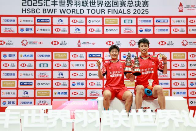 (251221) -- HANGZHOU, Dec. 21, 2025 (Xinhua) -- Gold medalists Feng Yanzhe (R)/Huang Dongping of China pose during the awarding ceremony after the mixed doubles final match between Feng Yanzhe/Huang Dongping of China and Jiang Zhenbang/Wei Yaxin of China at BWF World Tour Finals 2025 in Hangzhou, east China's Zhejiang Province, Dec. 21, 2025. (Xinhua/Jiang Han)