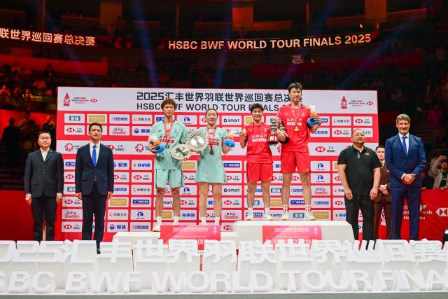 (251221) -- HANGZHOU, Dec. 21, 2025 (Xinhua) -- Gold medalists Feng Yanzhe (4th R)/Huang Dongping (5th R) of China and silver medalists Jiang Zhenbang (3rd L)/Wei Yaxin (4th L) of China pose during the awarding ceremony after the mixed doubles final match at BWF World Tour Finals 2025 in Hangzhou, east China's Zhejiang Province, Dec. 21, 2025. (Xinhua/Jiang Han)