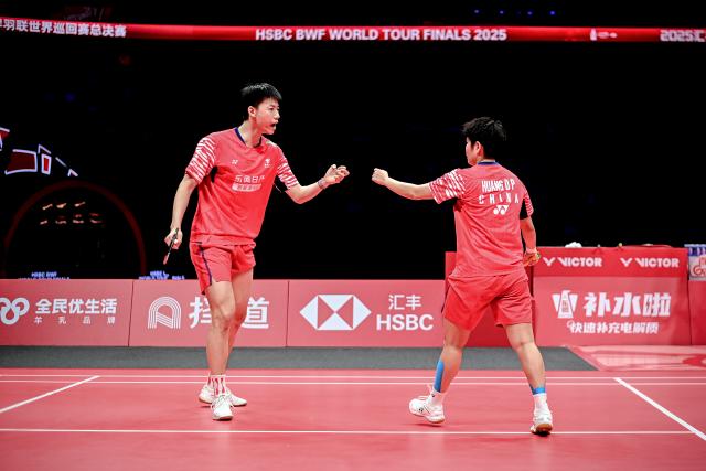 (251221) -- HANGZHOU, Dec. 21, 2025 (Xinhua) -- Feng Yanzhe (L)/Huang Dongping celebrate scoring during the mixed doubles final match between Feng Yanzhe/Huang Dongping of China and Jiang Zhenbang/Wei Yaxin of China at BWF World Tour Finals 2025 in Hangzhou, east China's Zhejiang Province, Dec. 21, 2025. (Xinhua/Jiang Han)