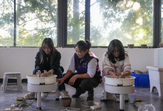 (251221) -- MOJIANG, Dec. 21, 2025 (Xinhua) -- An instructor (2nd L) teaches tourists to make pottery at a study tour center in Manhai Village, Mojiang Hani Autonomous County of Pu'er City, southwest China's Yunnan Province, Dec. 20, 2025. Manhai Village, located in Mojiang Hani Autonomous County of Pu'er City, is home to people from various ethnic groups. In recent years, with the help of the local government, the village has made significant strides in rural revitalization. 
  Manhai has converted idle houses into homestays and study tour centers. The village has also leveraged its intangible cultural heritage, such as bamboo weaving, to develop study tour classes and cultural and creative products. Furthermore, Manhai has trained villagers to run homestays and act as instructors during study tours. 
  Nowadays, the village has attracted many tourists and entrepreneurs to visit and start businesses. (Xinhua/Chen Xinbo)