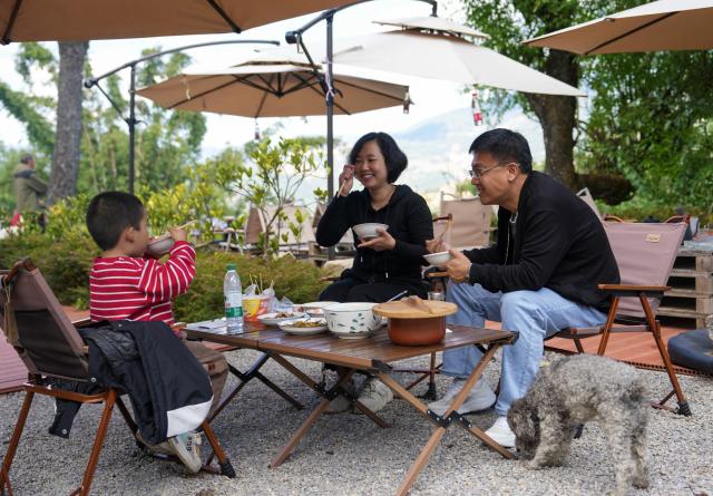 (251221) -- MOJIANG, Dec. 21, 2025 (Xinhua) -- Tourists have a meal in Manhai Village, Mojiang Hani Autonomous County of Pu'er City, southwest China's Yunnan Province, Dec. 20, 2025. Manhai Village, located in Mojiang Hani Autonomous County of Pu'er City, is home to people from various ethnic groups. In recent years, with the help of the local government, the village has made significant strides in rural revitalization. 
  Manhai has converted idle houses into homestays and study tour centers. The village has also leveraged its intangible cultural heritage, such as bamboo weaving, to develop study tour classes and cultural and creative products. Furthermore, Manhai has trained villagers to run homestays and act as instructors during study tours. 
  Nowadays, the village has attracted many tourists and entrepreneurs to visit and start businesses. (Xinhua/Chen Xinbo)