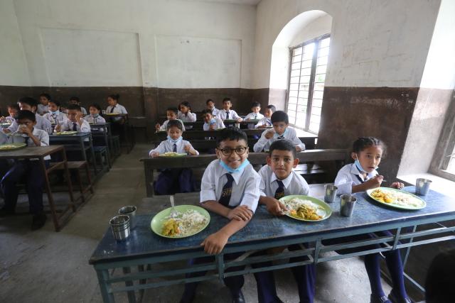 (251221) -- BEIJING, Dec. 21, 2025 (Xinhua) -- Students have lunch in a dining room following the launch ceremony of Nepal Smiling Children Project funded by the Global Development and South-South Cooperation Fund in Kathmandu, Nepal, July 11, 2022. (Xinhua/Yi Aijun)