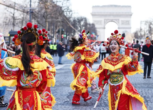 (251221) -- BEIJING, Dec. 21, 2025 (Xinhua) -- Members of a Yingge team perform Chaoyang Yingge dance during the Spring Festival celebration on the Champs-Elysees avenue in Paris, France, Feb. 2, 2025. (Xinhua/Gao Jing)