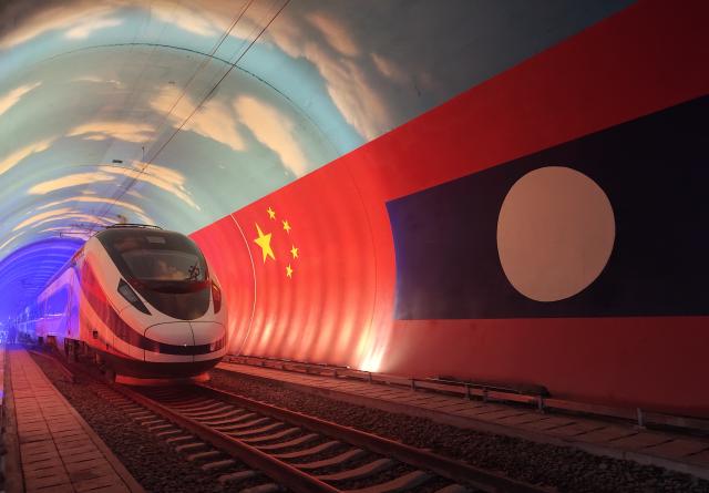 (251221) -- BEIJING, Dec. 21, 2025 (Xinhua) -- The Lane Xang EMU train passes by the China-Laos borderline inside a tunnel, Oct. 15, 2021. (Photo by Cao Anning/Xinhua)