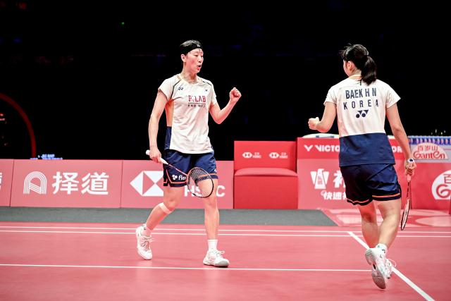 (251221) -- HANGZHOU, Dec. 21, 2025 (Xinhua) -- Baek Ha Na/Lee So Hee (L) of South Korea celebrate scoring during the women's doubles final between Baek Ha Na/Lee So Hee of South Korea and Fukushima Yuki/Matsumoto Mayu of Japan at BWF World Tour Finals 2025 in Hangzhou, east China's Zhejiang Province, Dec. 21, 2025. (Xinhua/Jiang Han)