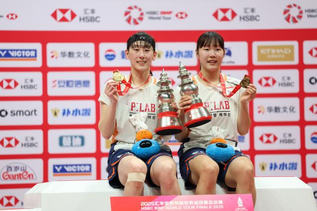 (251221) -- HANGZHOU, Dec. 21, 2025 (Xinhua) -- Baek Ha Na/Lee So Hee (L) of South Korea pose on the podium during the awarding ceremony after the women's doubles final between Baek Ha Na/Lee So Hee of South Korea and Fukushima Yuki/Matsumoto Mayu of Japan at BWF World Tour Finals 2025 in Hangzhou, east China's Zhejiang Province, Dec. 21, 2025. (Xinhua/Jiang Han)