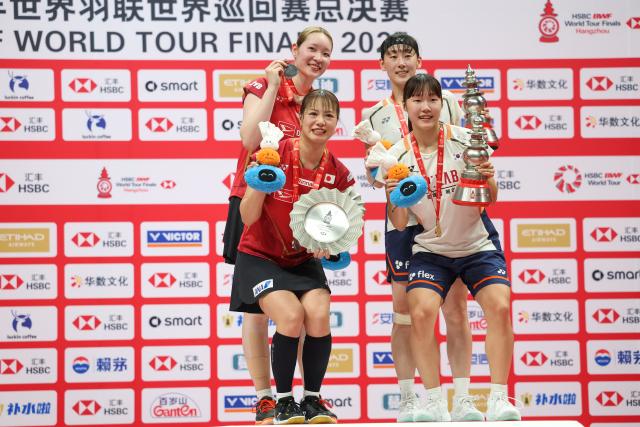 (251221) -- HANGZHOU, Dec. 21, 2025 (Xinhua) -- Baek Ha Na (below R)/Lee So Hee (top R) of South Korea and Fukushima Yuki (below L)/Matsumoto Mayu of Japan pose on the podium during the awarding ceremony after the women's doubles final at BWF World Tour Finals 2025 in Hangzhou, east China's Zhejiang Province, Dec. 21, 2025. (Xinhua/Jiang Han)