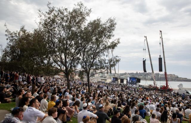 (251221) -- SYDNEY, Dec. 21, 2025 (Xinhua) -- People gather at Bondi Beach for a memorial service to honor the victims of the deadly terror attack a week earlier in Sydney, Australia, Dec. 21, 2025, the National Day of Reflection. (Xinhua/Ma Ping)