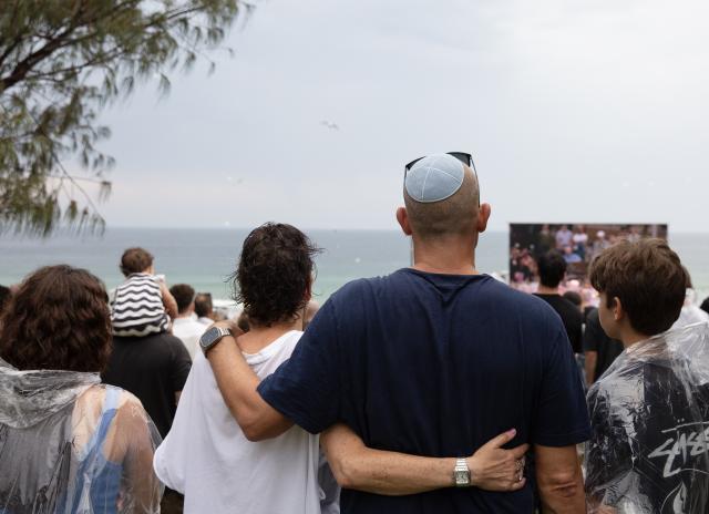(251221) -- SYDNEY, Dec. 21, 2025 (Xinhua) -- People gather at Bondi Beach for a memorial service to honor the victims of the deadly terror attack a week earlier in Sydney, Australia, Dec. 21, 2025, the National Day of Reflection. (Xinhua/Ma Ping)