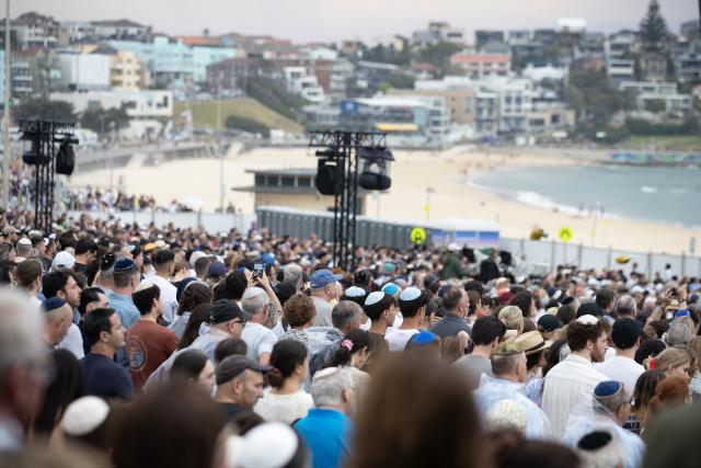 (251221) -- SYDNEY, Dec. 21, 2025 (Xinhua) -- People gather at Bondi Beach for a memorial service to honor the victims of the deadly terror attack a week earlier in Sydney, Australia, Dec. 21, 2025, the National Day of Reflection. (Xinhua/Ma Ping)