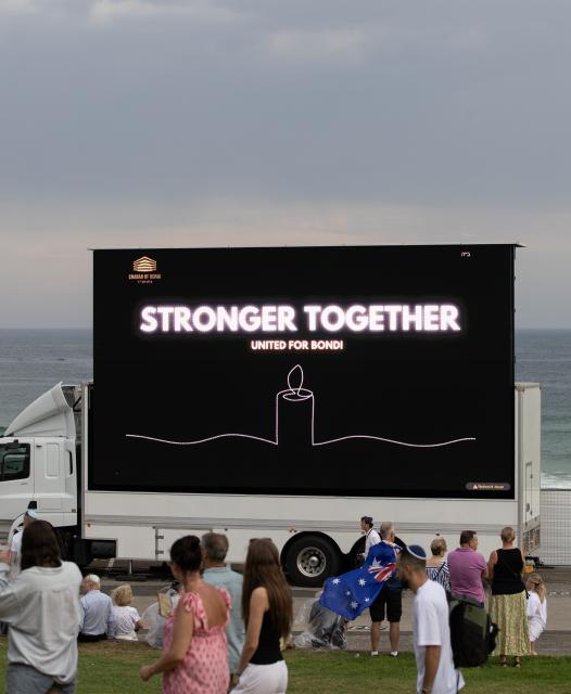 (251221) -- SYDNEY, Dec. 21, 2025 (Xinhua) -- People gather at Bondi Beach for a memorial service to honor the victims of the deadly terror attack a week earlier in Sydney, Australia, Dec. 21, 2025, the National Day of Reflection. (Xinhua/Ma Ping)