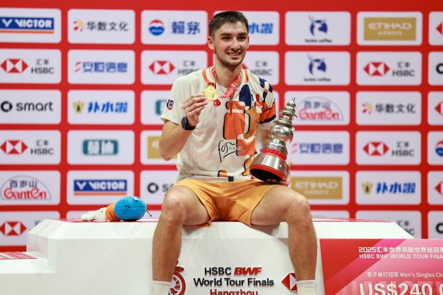 (251221) -- HANGZHOU, Dec. 21, 2025 (Xinhua) -- Winner Christo Popov poses during the awarding ceremony for the men's singles final between Shi Yuqi of China and Christo Popov of France at BWF World Tour Finals 2025 in Hangzhou, east China's Zhejiang Province, Dec. 21, 2025. (Xinhua/Jiang Han)