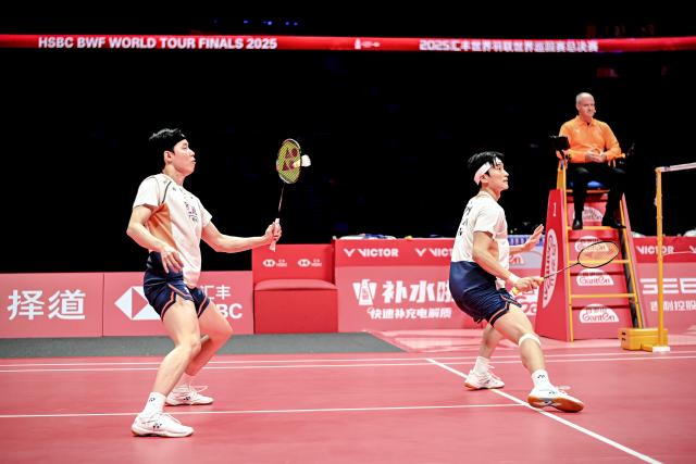 (251221) -- HANGZHOU, Dec. 21, 2025 (Xinhua) -- Kim Won Ho (R)/Seo Seung Jae of South Korea compete during the men's doubles final match between Liang Weikeng/Wang Chang of China and Kim Won Ho/Seo Seung Jae of South Korea at BWF World Tour Finals 2025 in Hangzhou, east China's Zhejiang Province, Dec. 21, 2025. (Xinhua/Jiang Han)