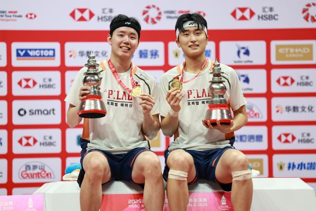(251221) -- HANGZHOU, Dec. 21, 2025 (Xinhua) -- Kim Won Ho (R)/Seo Seung Jae of South Korea pose at the awarding ceremony after the men's doubles final match between Liang Weikeng/Wang Chang of China and Kim Won Ho/Seo Seung Jae of South Korea at BWF World Tour Finals 2025 in Hangzhou, east China's Zhejiang Province, Dec. 21, 2025. (Xinhua/Jiang Han)