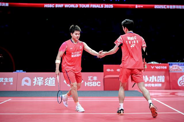 (251221) -- HANGZHOU, Dec. 21, 2025 (Xinhua) -- Liang Weikeng (L)/Wang Chang of China celebrate during the men's doubles final match between Liang Weikeng/Wang Chang of China and Kim Won Ho/Seo Seung Jae of South Korea at BWF World Tour Finals 2025 in Hangzhou, east China's Zhejiang Province, Dec. 21, 2025. (Xinhua/Jiang Han)