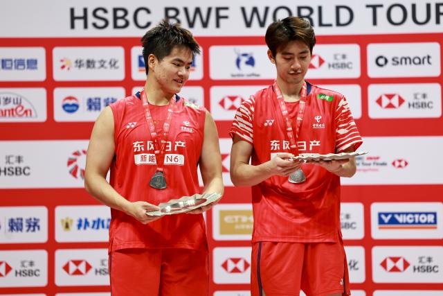 (251221) -- HANGZHOU, Dec. 21, 2025 (Xinhua) -- Liang Weikeng/Wang Chang (R) of China pose at the awarding ceremony after the men's doubles final match between Liang Weikeng/Wang Chang of China and Kim Won Ho/Seo Seung Jae of South Korea at BWF World Tour Finals 2025 in Hangzhou, east China's Zhejiang Province, Dec. 21, 2025. (Xinhua/Jiang Han)