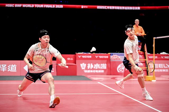 (251221) -- HANGZHOU, Dec. 21, 2025 (Xinhua) -- Kim Won Ho (R)/Seo Seung Jae of South Korea compete during the men's doubles final match between Liang Weikeng/Wang Chang of China and Kim Won Ho/Seo Seung Jae of South Korea at BWF World Tour Finals 2025 in Hangzhou, east China's Zhejiang Province, Dec. 21, 2025. (Xinhua/Jiang Han)