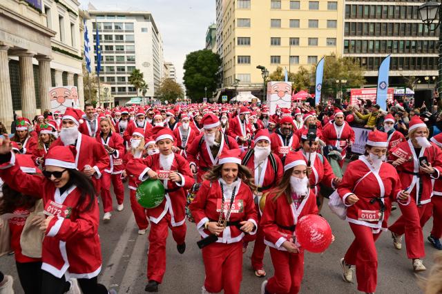 (251221) -- ATHENS, Dec. 21, 2025 (Xinhua) -- People participate in the Athens Santa Run 2025 in Athens, Greece, Dec. 21, 2025. Thousands of participants dressed as Santa Claus joined the annual Athens Santa Run, a festive and charitable 2.8-km race. (Xinhua/Marios Lolos)