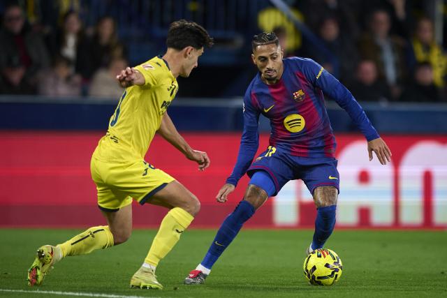 (251222) -- VILA-REAL, Dec. 22, 2025 (Xinhua) -- Sergi Cardona (L) of Villarreal vies with Raphinha of Barcelona during the La Liga football match between Villarreal and Barcelona in Vila-Real, Spain, Dec. 21, 2025. (Str/Xinhua)