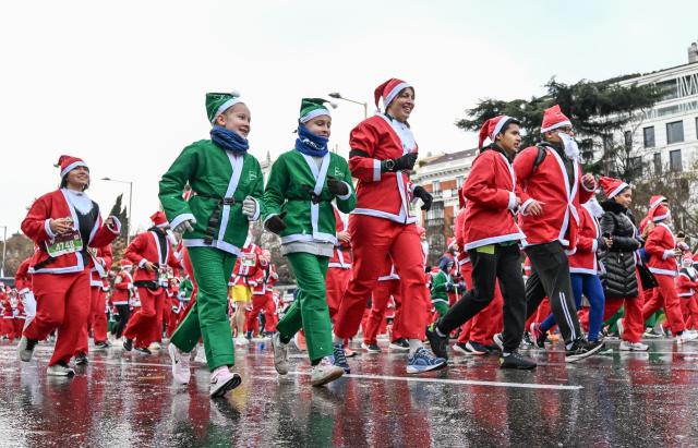 (251222) -- MADRID, Dec. 22, 2025 (Xinhua) -- Runners in Santa Claus costumes attend a Christmas-themed running event in Madrid, Spain, Dec. 21, 2025. (Xinhua/Cheng Min)