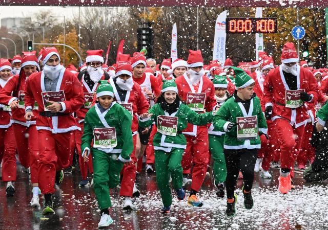 (251222) -- MADRID, Dec. 22, 2025 (Xinhua) -- Runners in Santa Claus costumes attend a Christmas-themed running event in Madrid, Spain, Dec. 21, 2025. (Xinhua/Cheng Min)