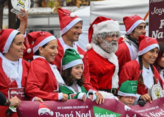 (251222) -- MADRID, Dec. 22, 2025 (Xinhua) -- Runners in Santa Claus costumes attend a Christmas-themed running event in Madrid, Spain, Dec. 21, 2025. (Xinhua/Cheng Min)