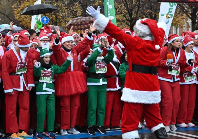 (251222) -- MADRID, Dec. 22, 2025 (Xinhua) -- Runners in Santa Claus costumes attend a Christmas-themed running event in Madrid, Spain, Dec. 21, 2025. (Xinhua/Cheng Min)