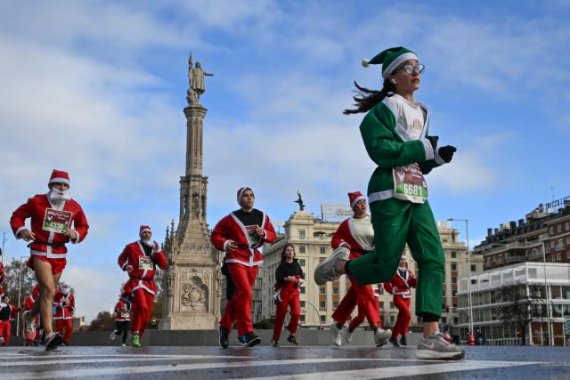 (251222) -- MADRID, Dec. 22, 2025 (Xinhua) -- Runners in Santa Claus costumes attend a Christmas-themed running event in Madrid, Spain, Dec. 21, 2025. (Xinhua/Cheng Min)