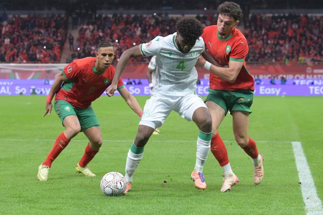 (251222) -- RABAT, Dec. 22, 2025 (Xinhua) -- Kenan Toubibou (C) of Comoros vies with Neli El Aynaoui (R) of Morocco during the opening match of the Africa Cup of Nations 2025 between Morocco and Comoros in Rabat, Morocco, Dec. 21, 2025. (Photo by Aissa/Xinhua)