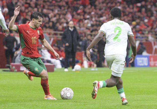 (251222) -- RABAT, Dec. 22, 2025 (Xinhua) -- Brahim Diaz (L) of Morocco passes the ball during the opening match of the Africa Cup of Nations 2025 between Morocco and Comoros in Rabat, Morocco, Dec. 21, 2025. (Photo by Aissa/Xinhua)