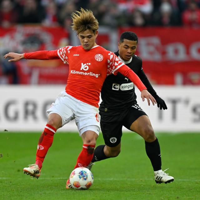 (251222) -- MAINZ, Dec. 22, 2025 (Xinhua) -- Sano Kaishu (front) of FSV Mainz 05 vies with Fujita Joel Chima of FC St. Pauli during the German first division Bundesliga football match between FSV Mainz 05 and FC St. Pauli in Mainz, Germany, Dec. 21, 2025. (Photo by Ulrich Hufnagel/Xinhua)