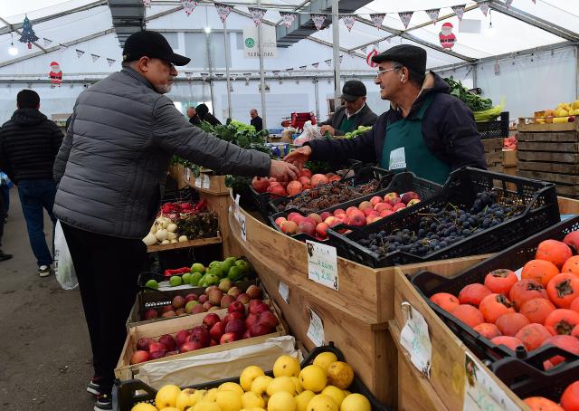 (251222) -- BAKU, Dec. 22, 2025 (Xinhua) -- People buy fruits at an agricultural products trade fair in Baku, Azerbaijan, Dec. 21, 2025. With more than 140 specialties from over 80 farms and agricultural product processing enterprises across the country, the trade fair opened here on Saturday, and will run through Dec. 30. (Xinhua/Chen Junfeng)