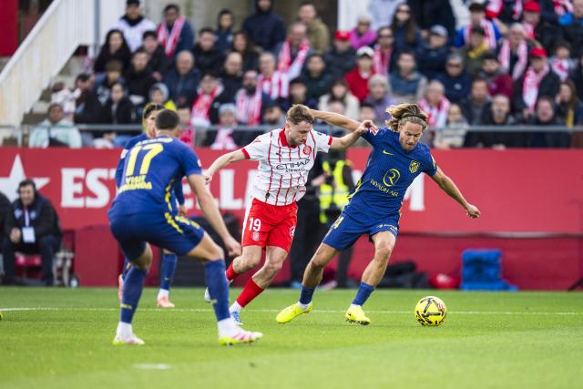 (251222) -- GIRONA, Dec. 22, 2025 (Xinhua) -- Marcos Llorente (R) of Atletico de Madrid vies with Vladyslav Vanat (C) of Girona FC during the La Liga football match between Girona FC and Atletico de Madrid in Montilivi Stadium, Girona, Spain, on Dec. 21, 2025. (Photo by Joan Gosa/Xinhua)