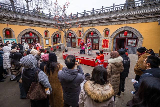 (251222) -- SANMENXIA, Dec. 22, 2025 (Xinhua) -- Tourists watch a drama performance at a traditional Dikengyuan residence in Beiying Village, Zhangbian Township, Shanzhou District, Sanmenxia City of central China's Henan Province, on Dec. 21, 2025.
  The Dikengyuan residence, a traditional residential construction in west Henan featuring a sunken courtyard, is of high value in the study of local history, architecture, geology and sociology. It was listed in the third batch of China's national intangible cultural heritage in 2011.
  In recent years, Sanmenxia has continuously advanced the restoration of these peculiar dwellings, turning them into tourist attractions to further boost development in their neighborhood. (Photo by Zhao Yongtao/Xinhua)