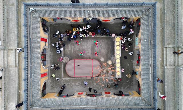 (251222) -- SANMENXIA, Dec. 22, 2025 (Xinhua) -- An aerial drone photo taken on Dec. 21, 2025 shows tourists watching a folk performance at a traditional Dikengyuan residence in Beiying Village, Zhangbian Township, Shanzhou District, Sanmenxia City of central China's Henan Province.
  The Dikengyuan residence, a traditional residential construction in west Henan featuring a sunken courtyard, is of high value in the study of local history, architecture, geology and sociology. It was listed in the third batch of China's national intangible cultural heritage in 2011.
  In recent years, Sanmenxia has continuously advanced the restoration of these peculiar dwellings, turning them into tourist attractions to further boost development in their neighborhood. (Photo by Niu Shupei/Xinhua)