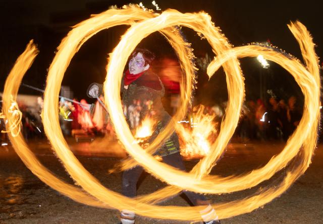 (251222) -- TORONTO, Dec. 22, 2025 (Xinhua) -- A woman performs with fire at the 2025 Kensington Market Winter Solstice event in Toronto, Canada, Dec. 21, 2025. The annual event to celebrate the longest night of the year was held here on Sunday. (Photo by Zou Zheng/Xinhua)